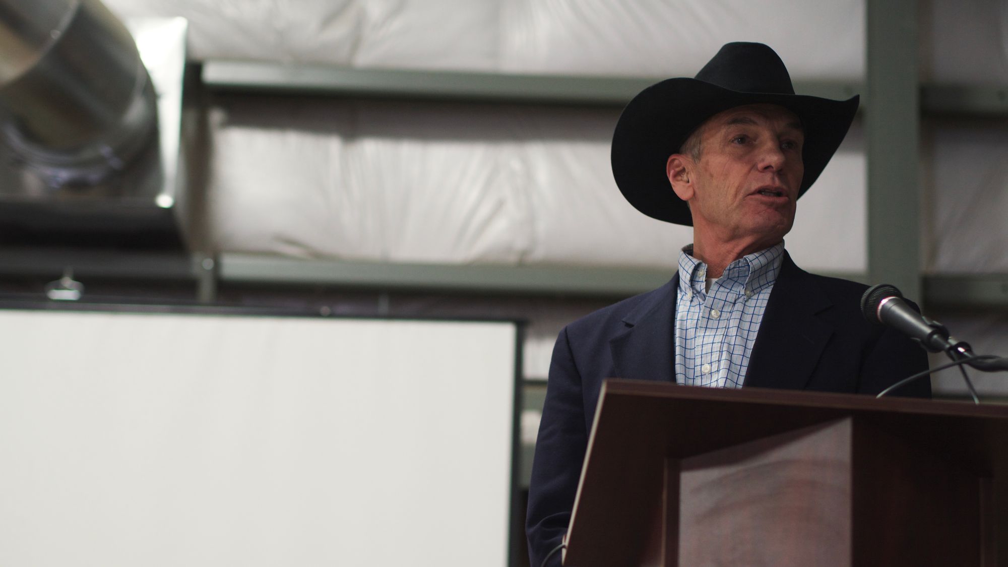County Commissioner Sam Schropp stands in front of a podium.